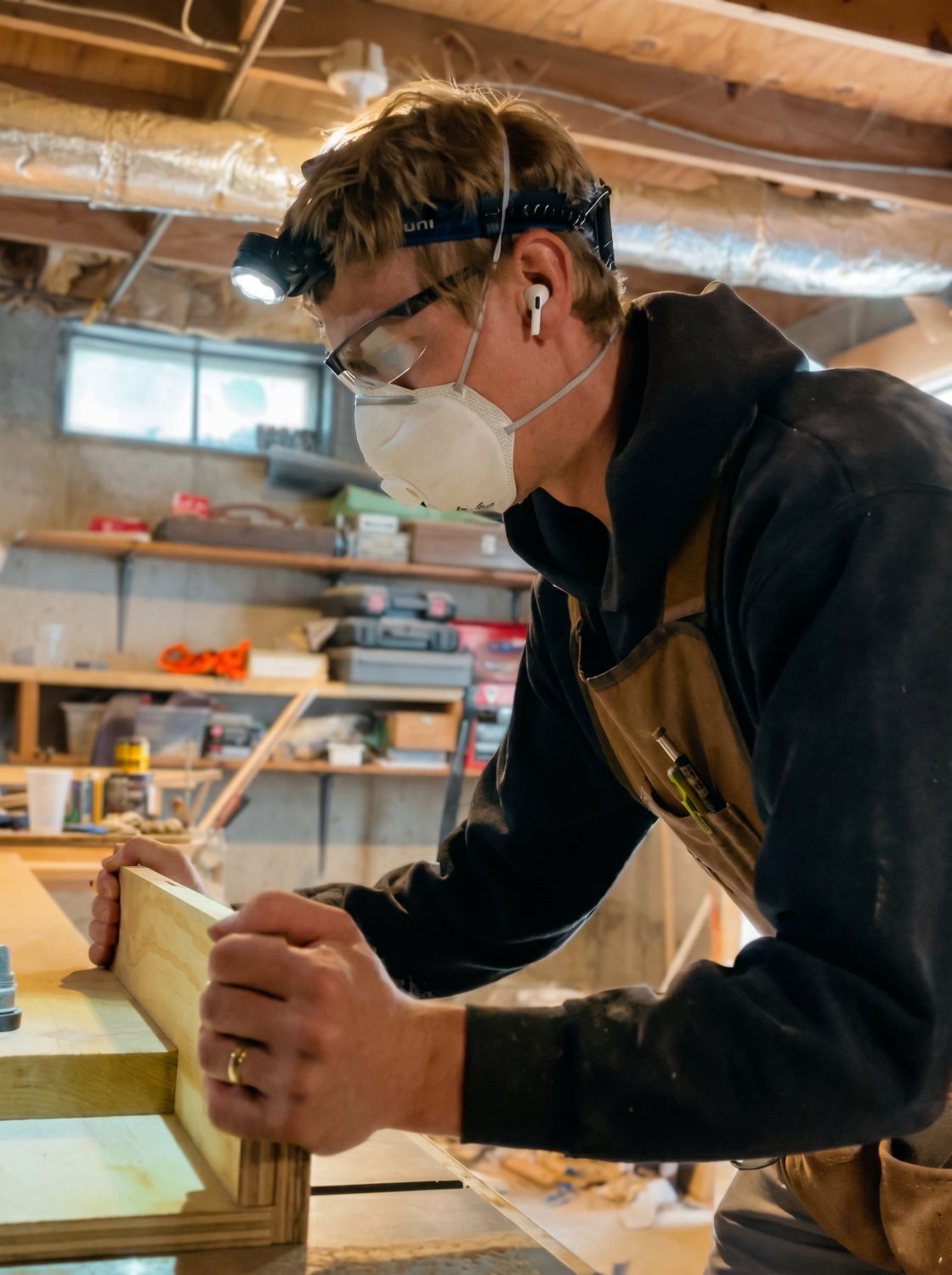 Michael Troutman working in his Kentucky woodworking shop with headlamp and dust mask